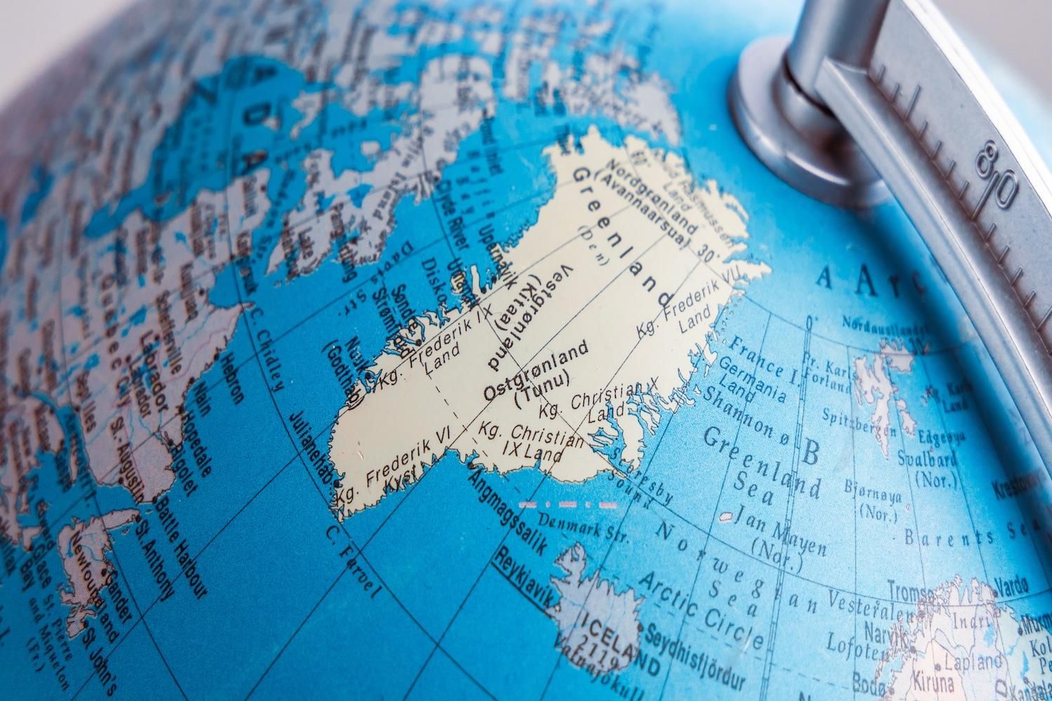 Closeup of a globe showing Greenland and surrounding Arctic regions.