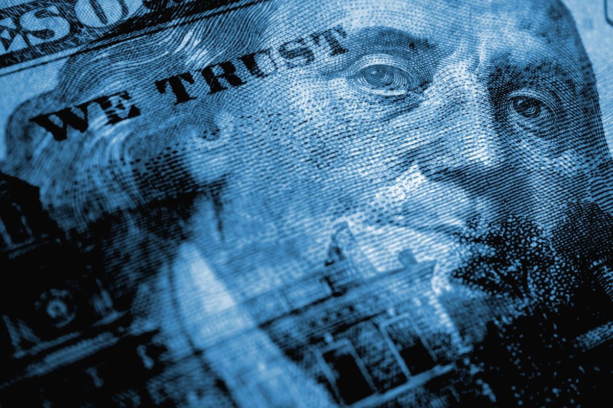 Closeup of a US bill with "we trust" text and a face.