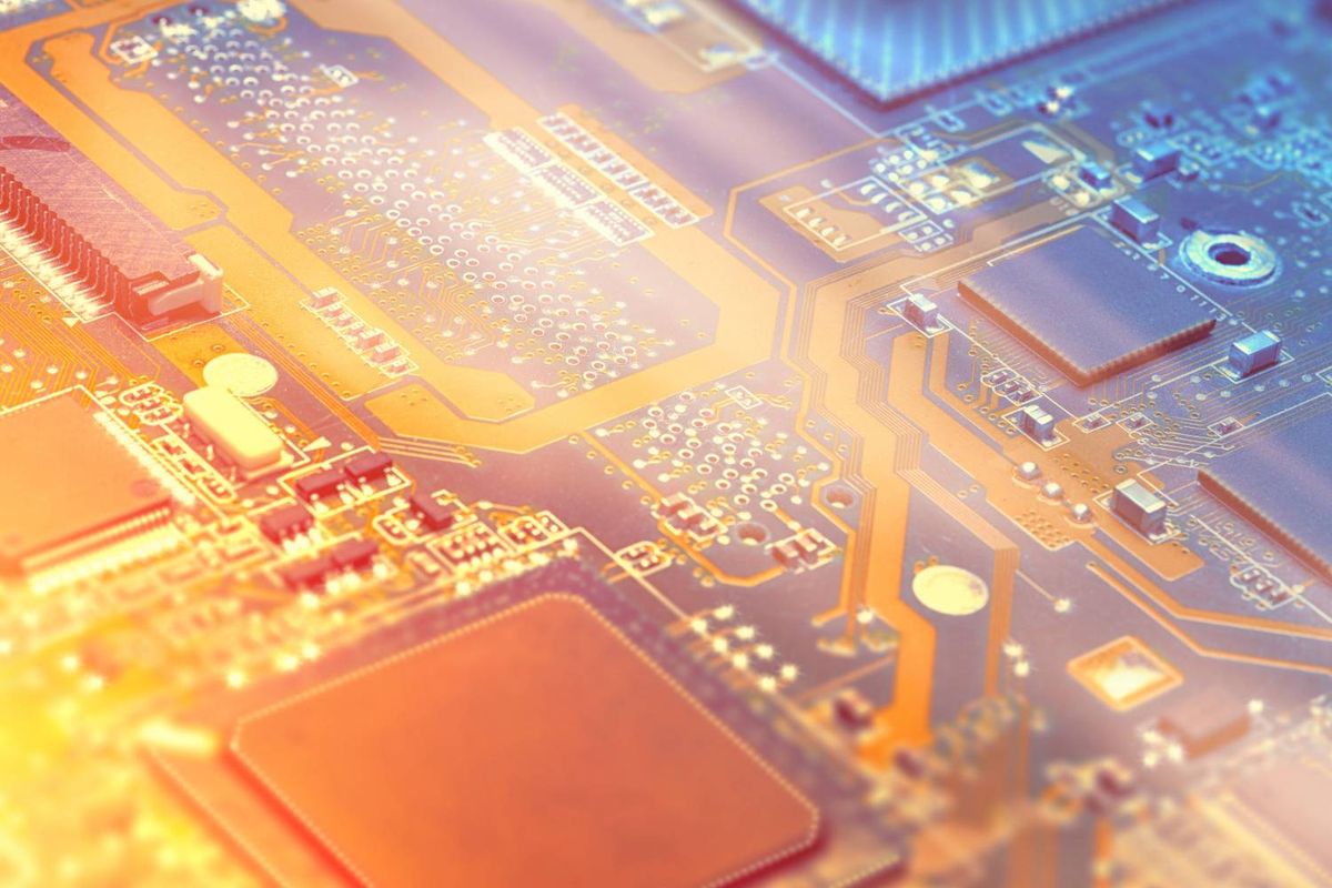 Closeup of an illuminated circuit board, featuring chips and pathways.