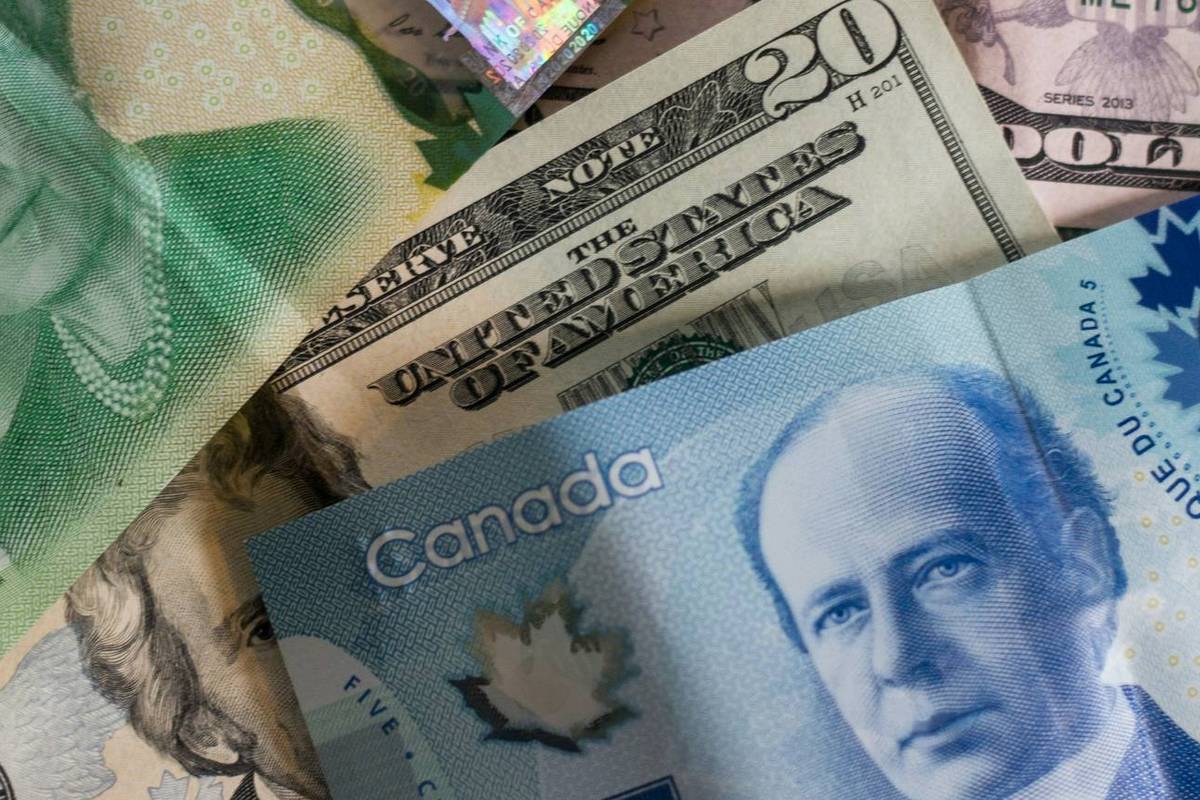 Closeup of Canadian and US currency bills overlapping.