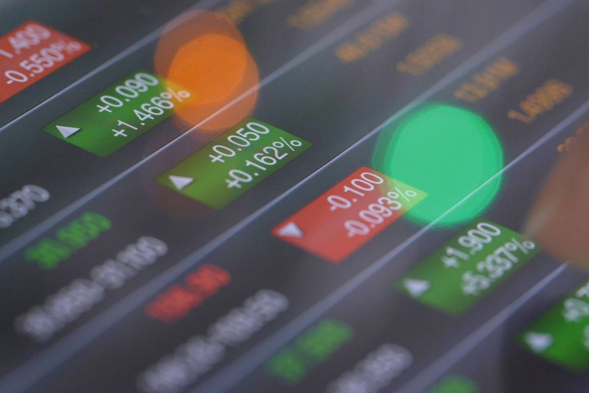 Closeup of digital stock market screen with green and red percentage indicators.