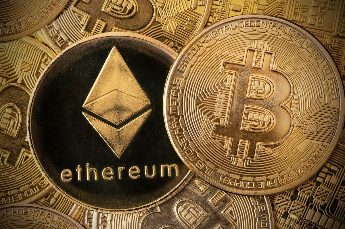 Closeup of Ethereum and Bitcoin coins overlapping with metallic gold finish.