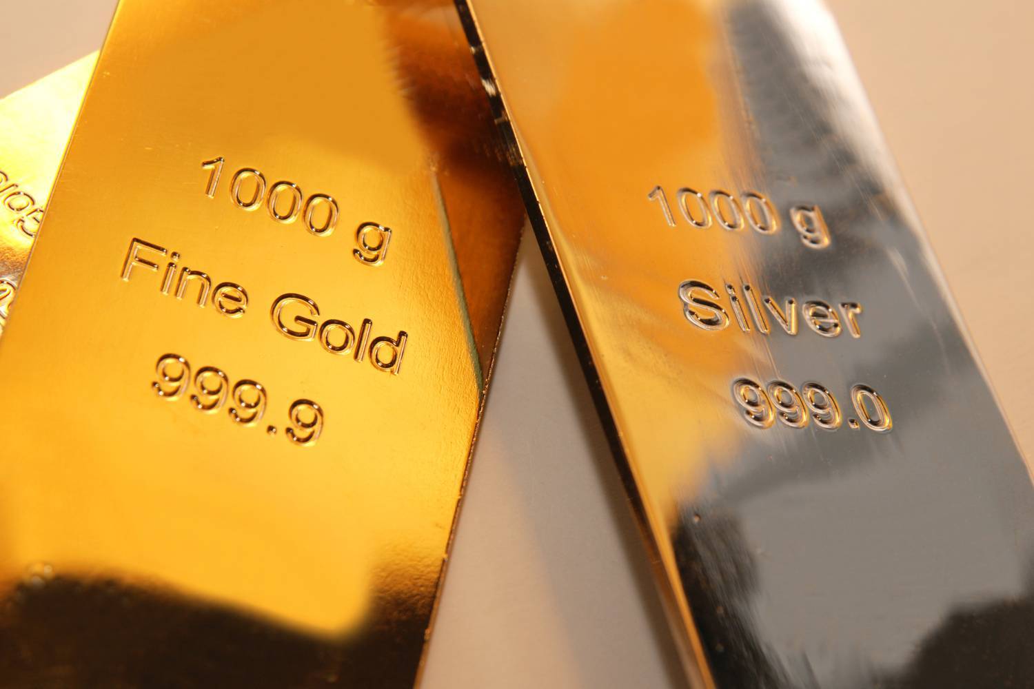 Closeup of gold and silver bars marked with purity levels.