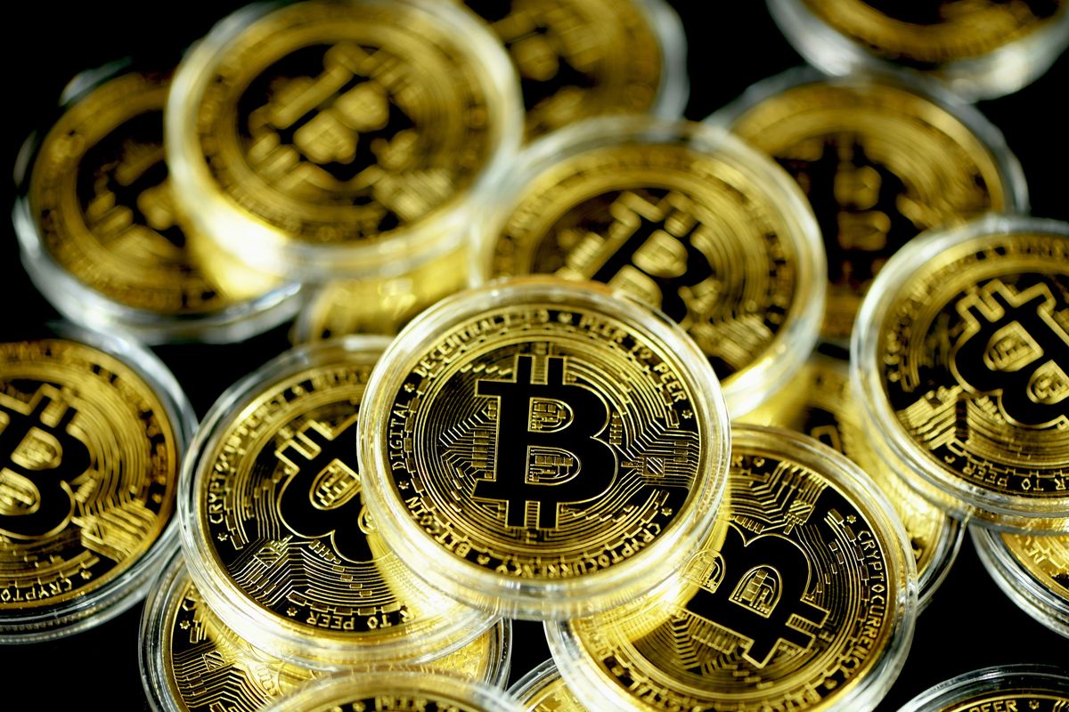 Closeup of multiple gold Bitcoin coins with the Bitcoin logo.
