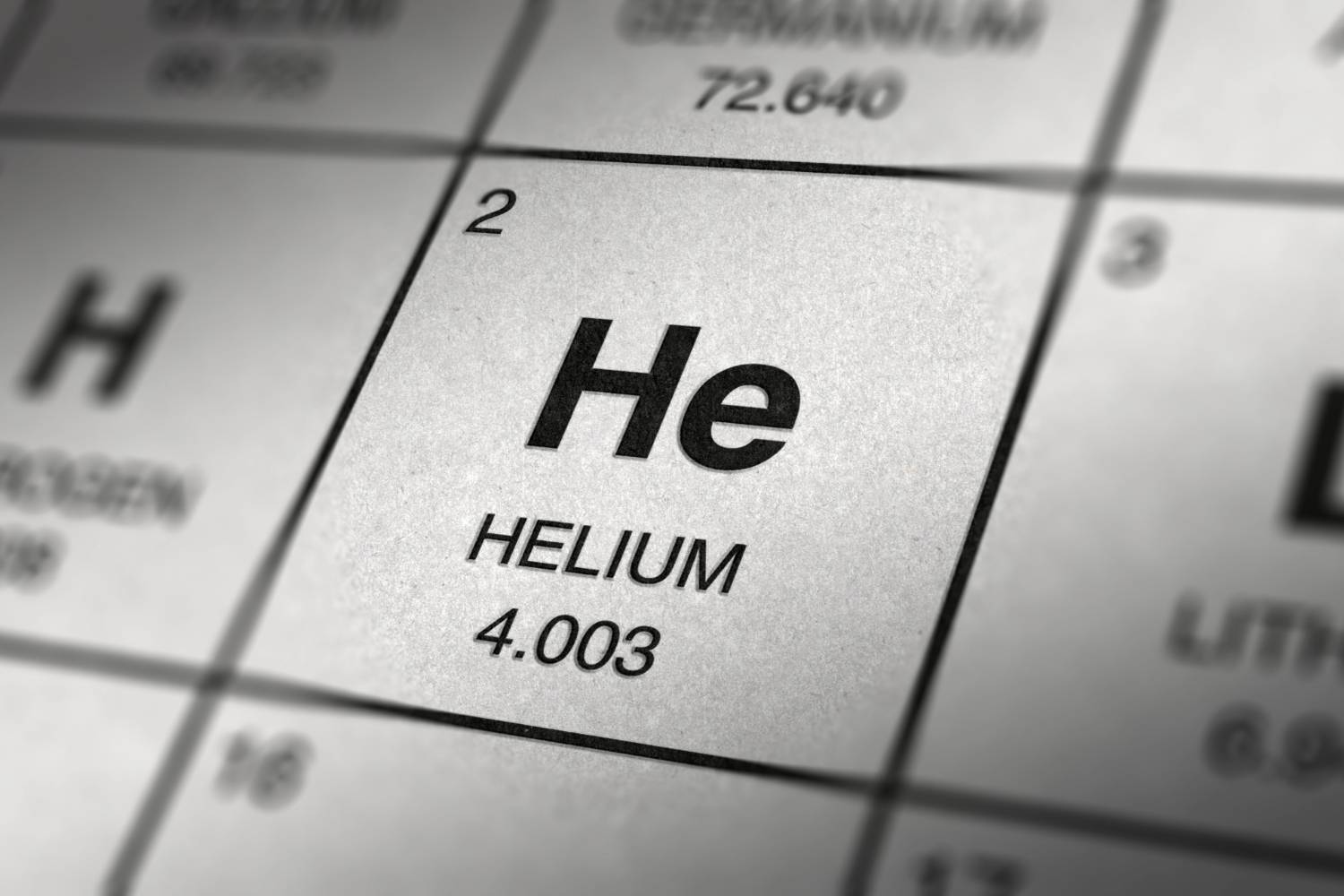 Closeup of periodic table featuring helium, labeled as "He," with atomic number 2 and weight 4.003.
