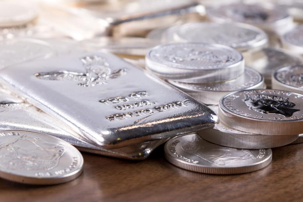 closeup of silver coins and bars on a wood table