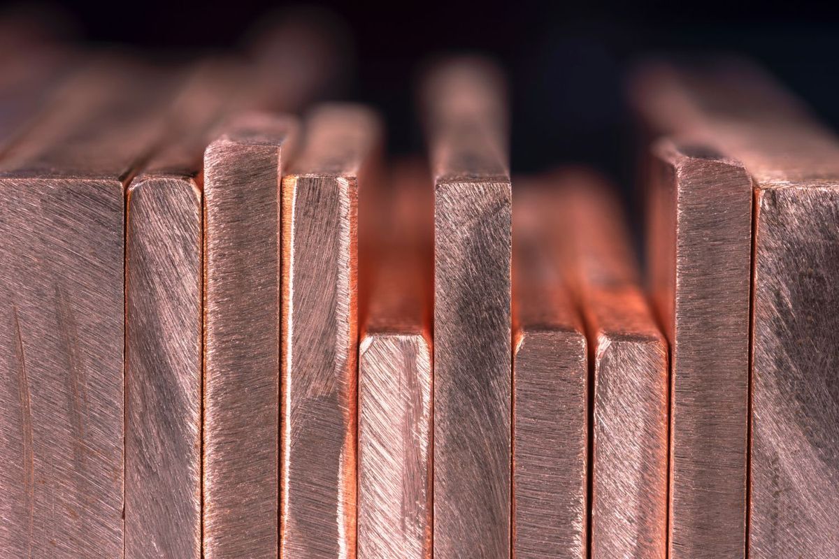 Closeup of stacked copper bars with a textured surface.