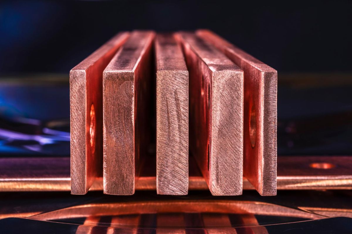 Closeup of stacked copper bars with reflective surface.