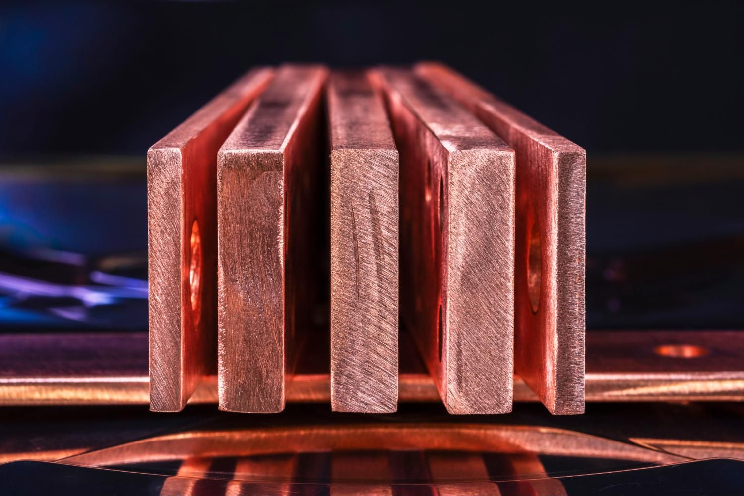 Closeup of stacked copper bars with reflective surface.
