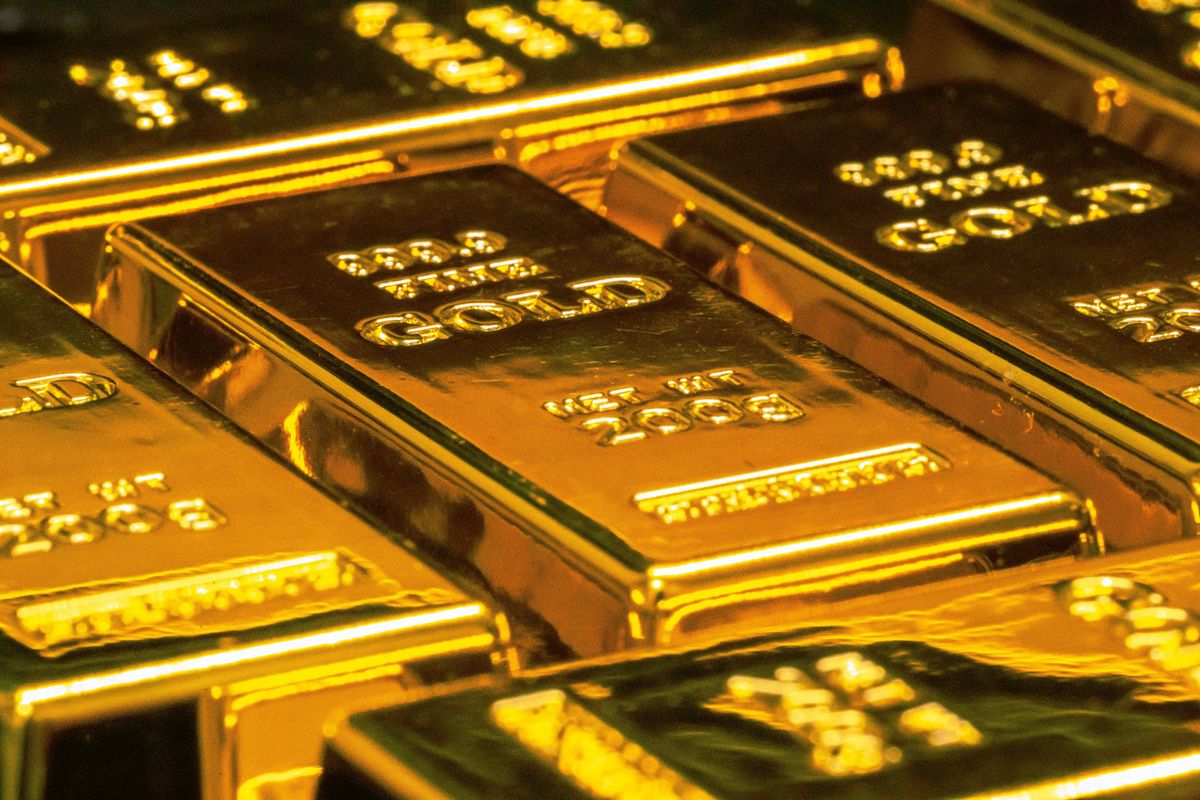 Closeup of stacked gold bars with engraved text.