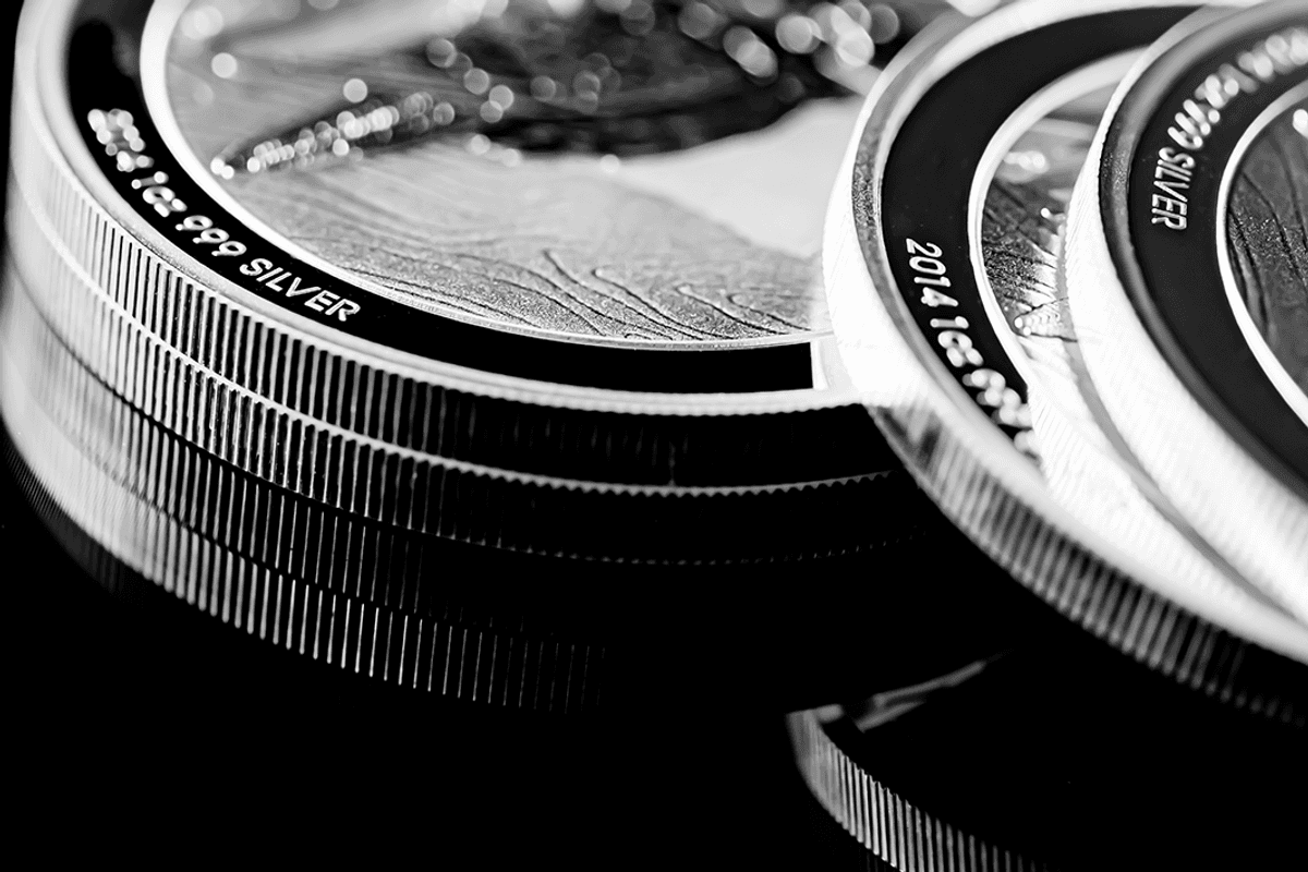 Closeup of stacked silver coins with engraved edges.