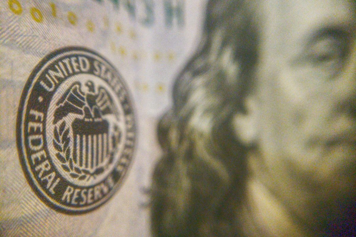 Closeup of US Federal Reserve seal on US bill with partial portrait visible.