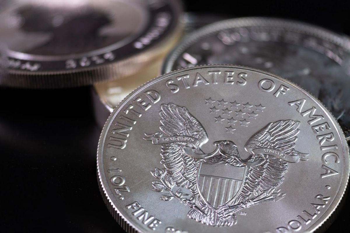 Closeup of US silver coins with eagle and stars design on a black background.