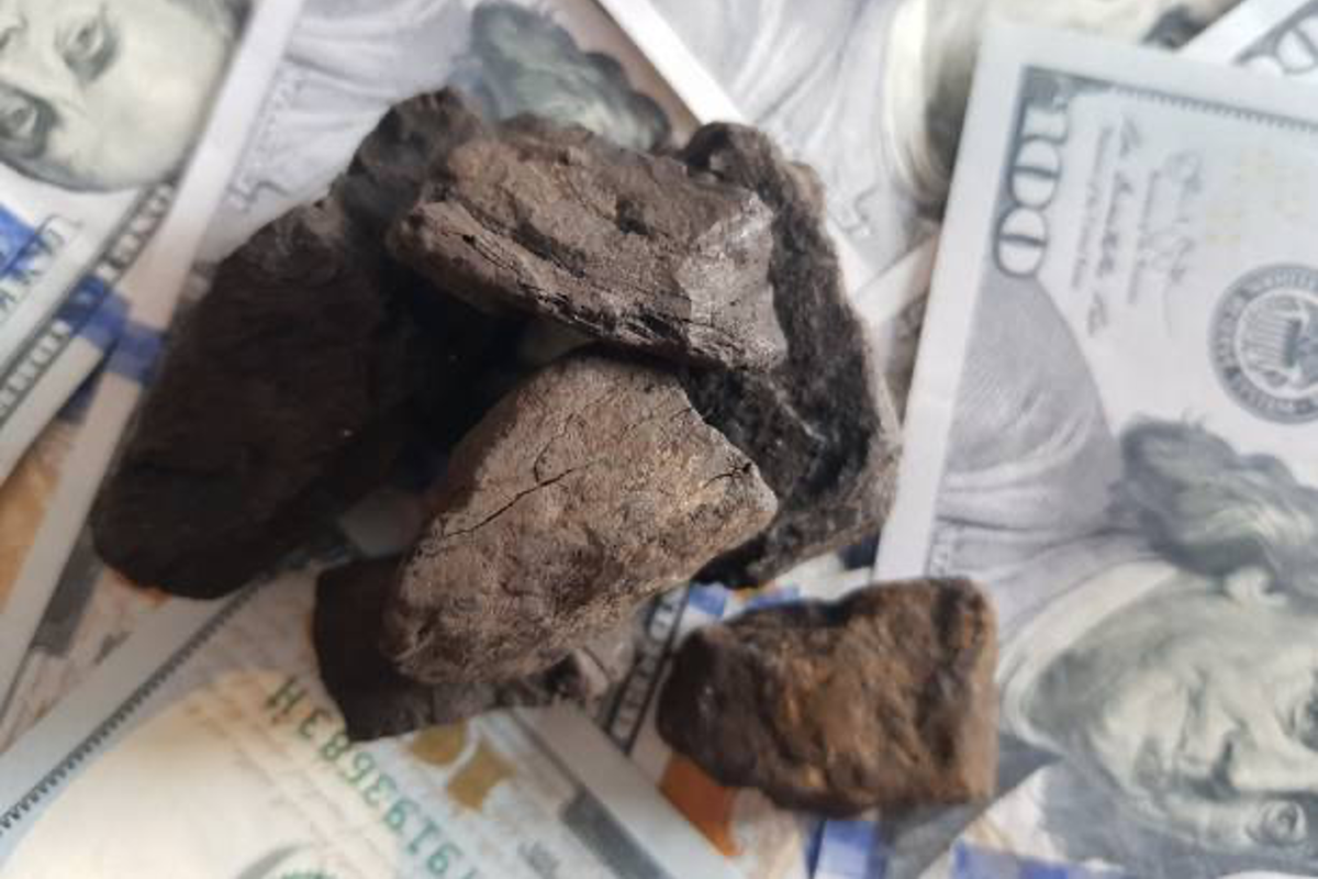 Coal on a bed of US banknotes.