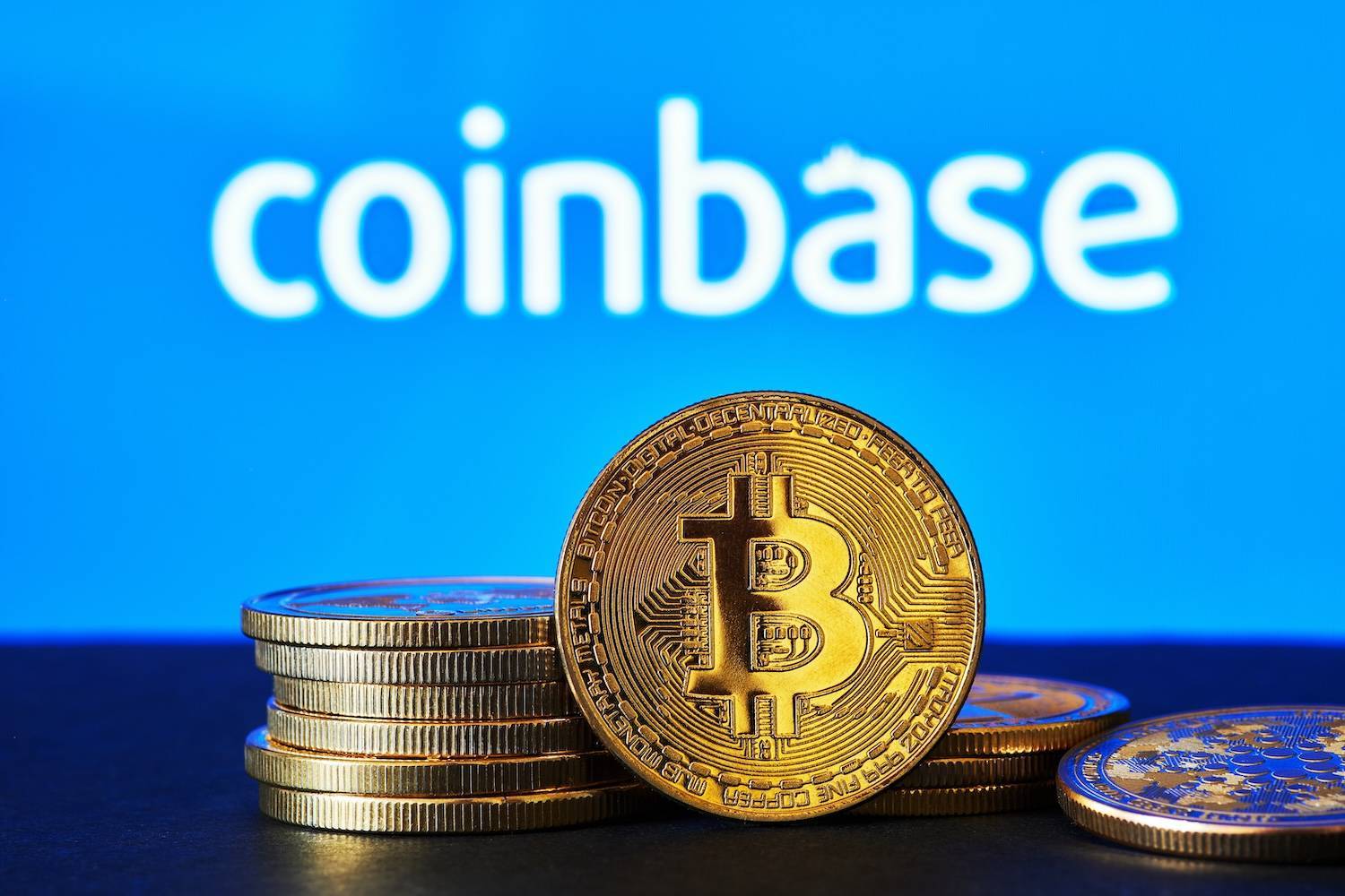Coinbase logo and a Bitcoin.