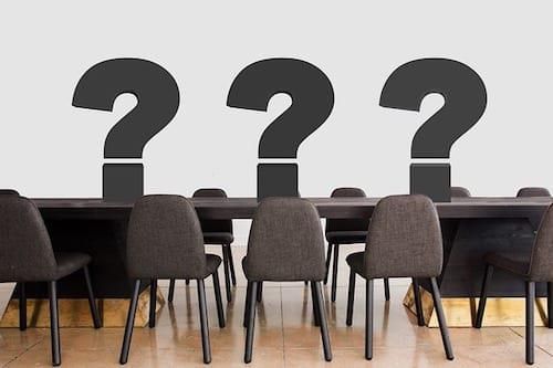 conference room table and chairs with 3 question marks on table