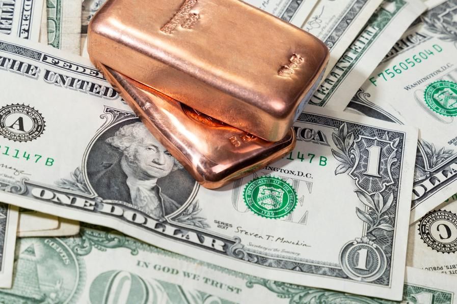 copper bars on top of US dollar bills