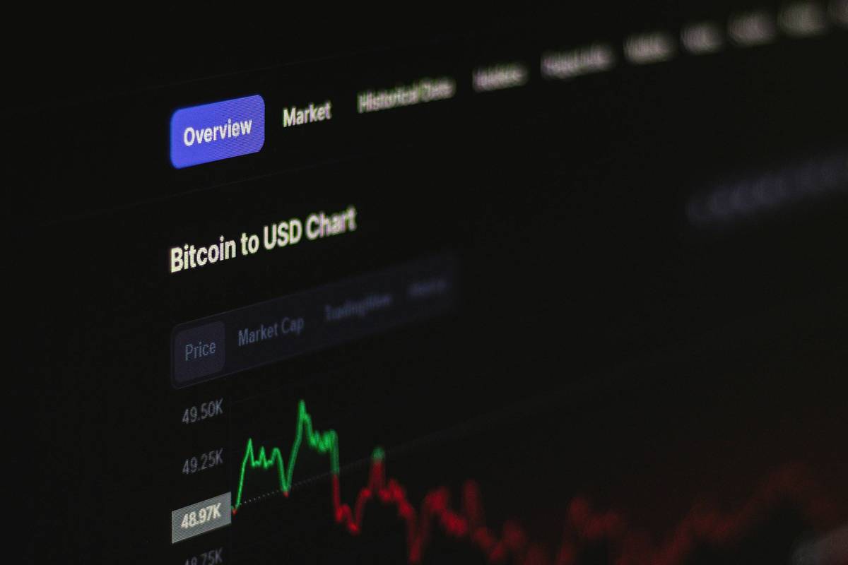 Dark screen showing Bitcoin to US dollar chart with green and red lines.