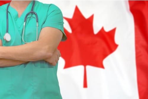 doctor standing in front of Canadian flag