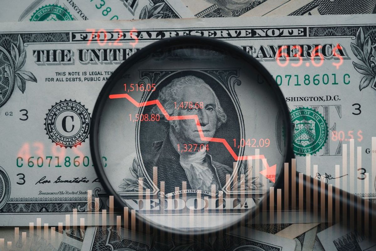 Dollar bill under magnifying glass with superimposed stock chart and prices.