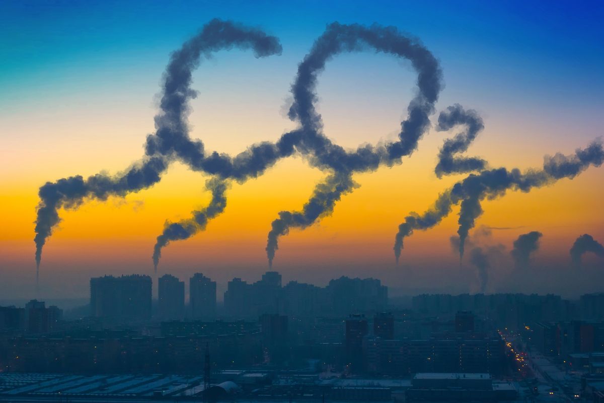 Evening view of a factor with C02 emissions from chimneys at sunset.