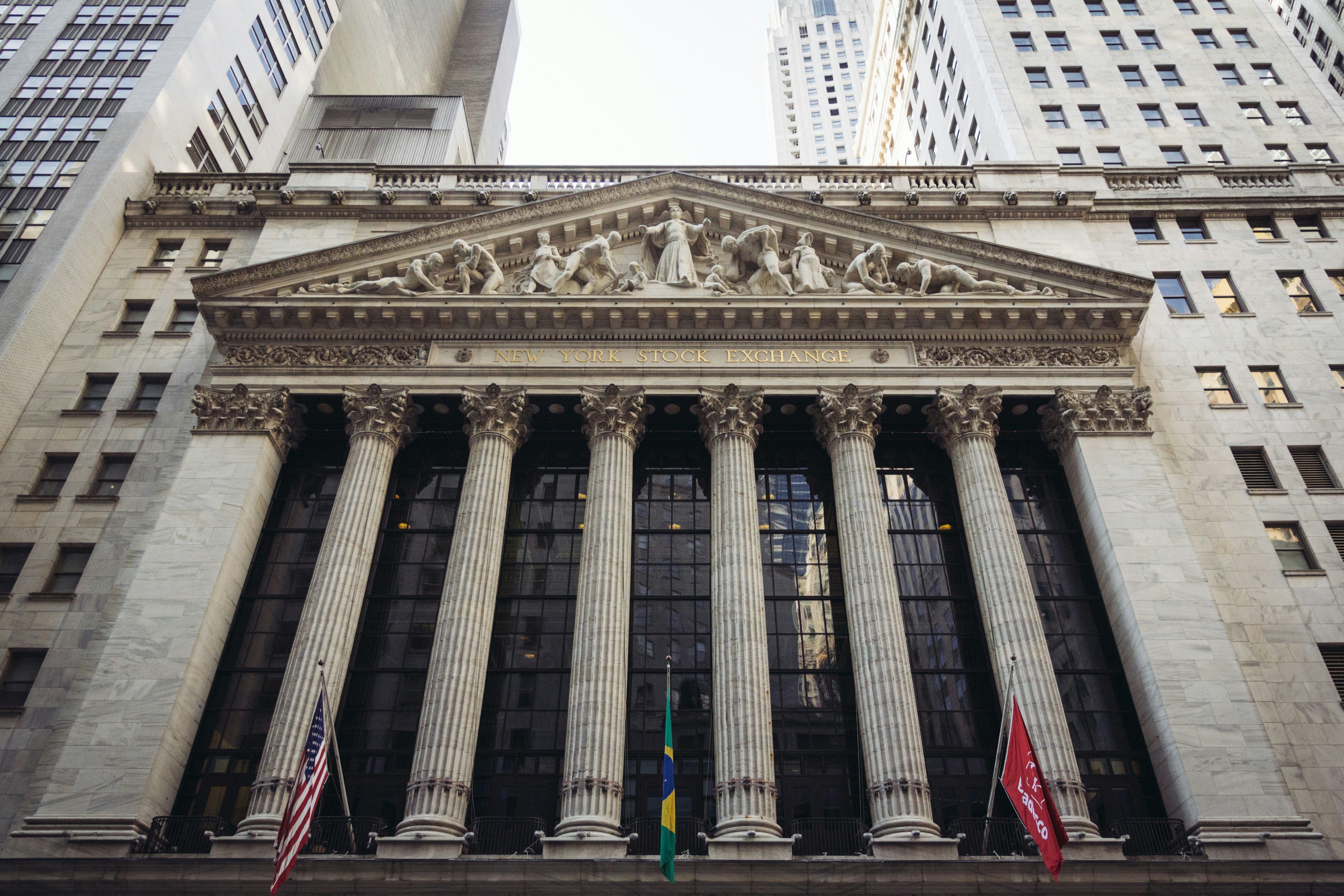 Facade of New York Stock Exchange with columns and flags.