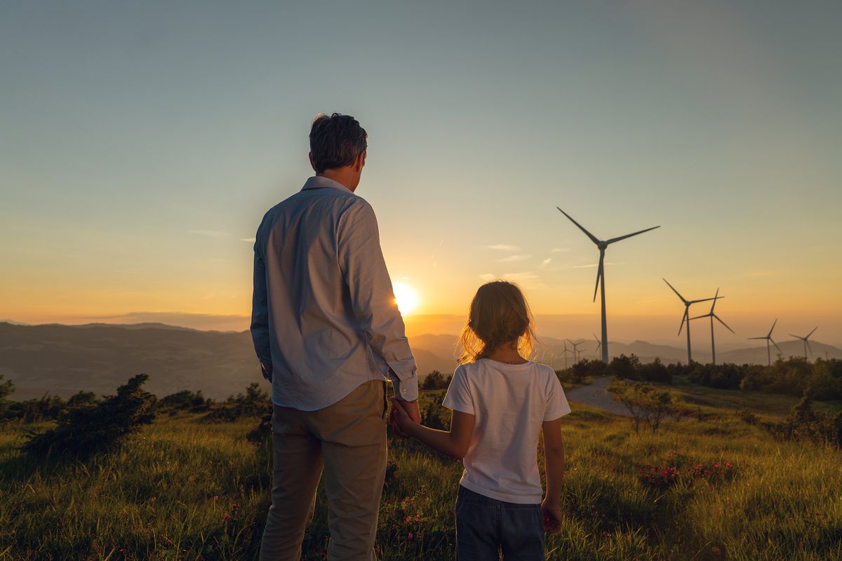 father and daughter looking at electric windmills