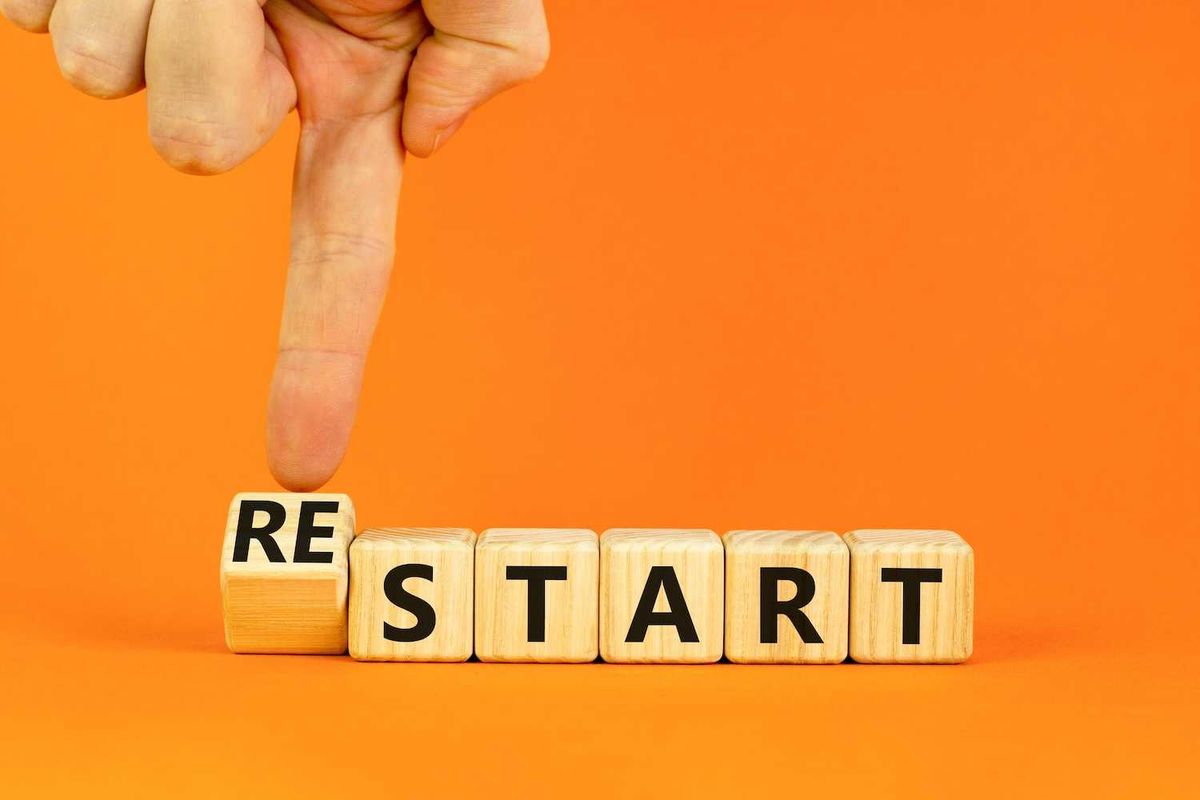 Finger flipping block from "restart" to "start" on orange background.