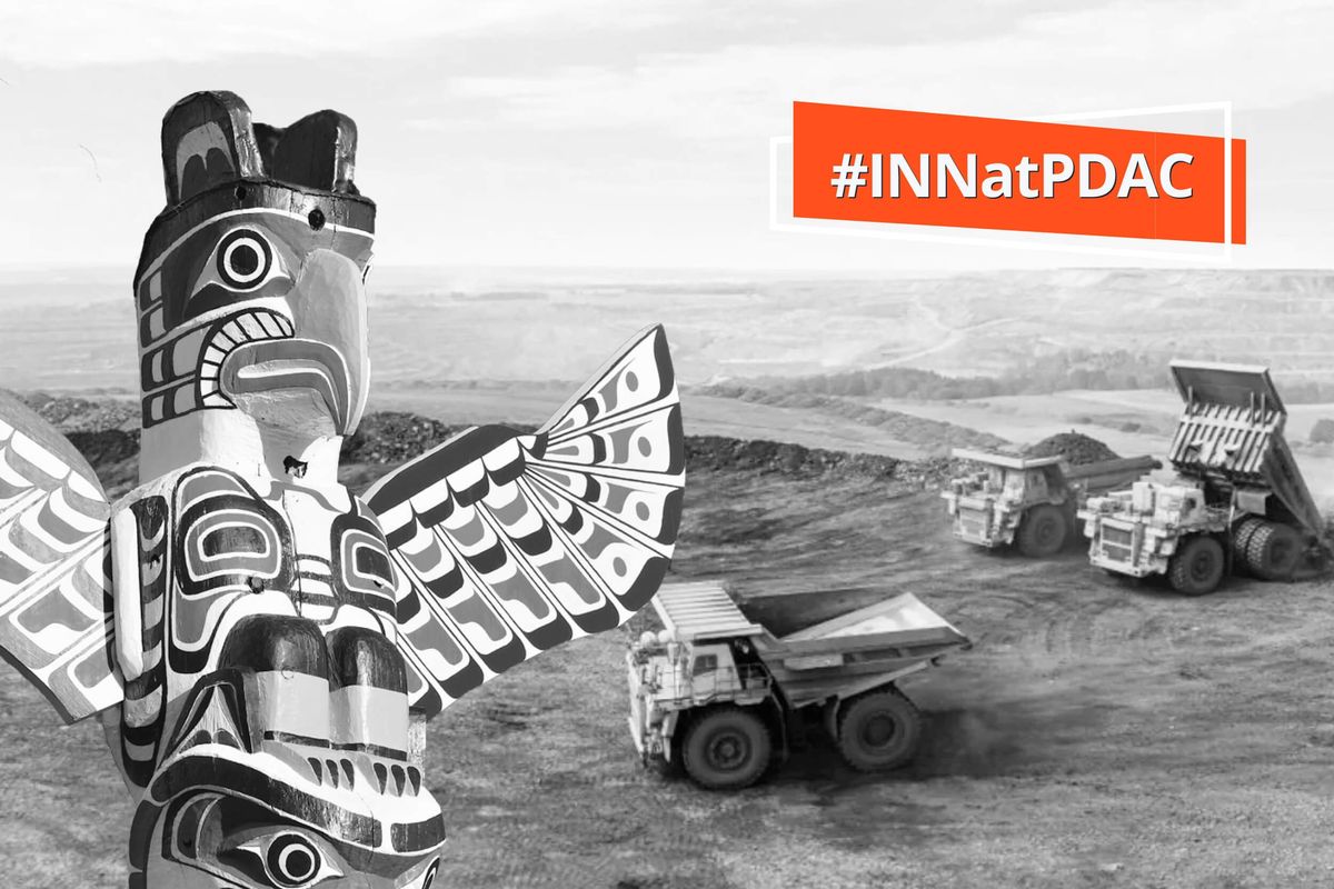 First Nations totem pole with mining trucks.