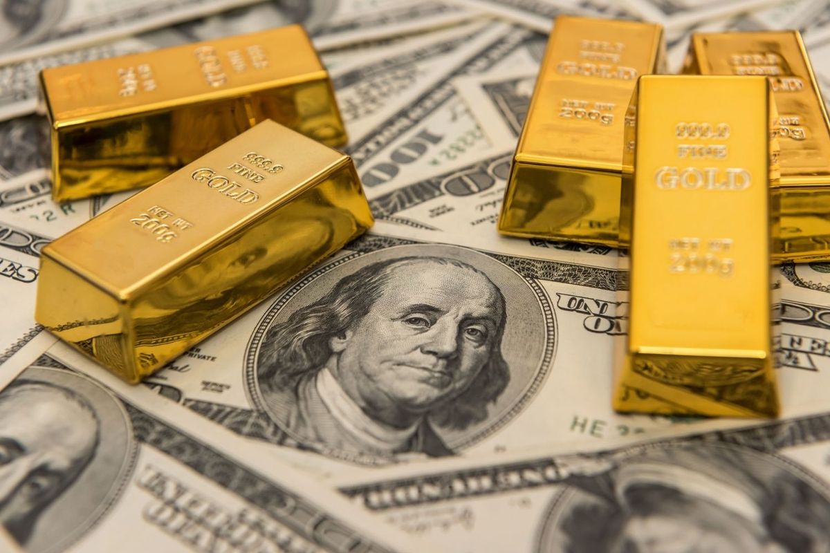 Five gold bars on top of spread out US $100 bills.