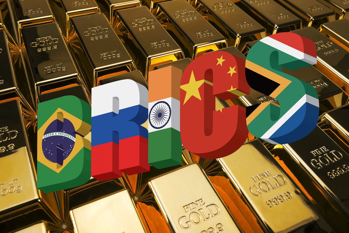 Flags of BRICS countries over background of gold bars.