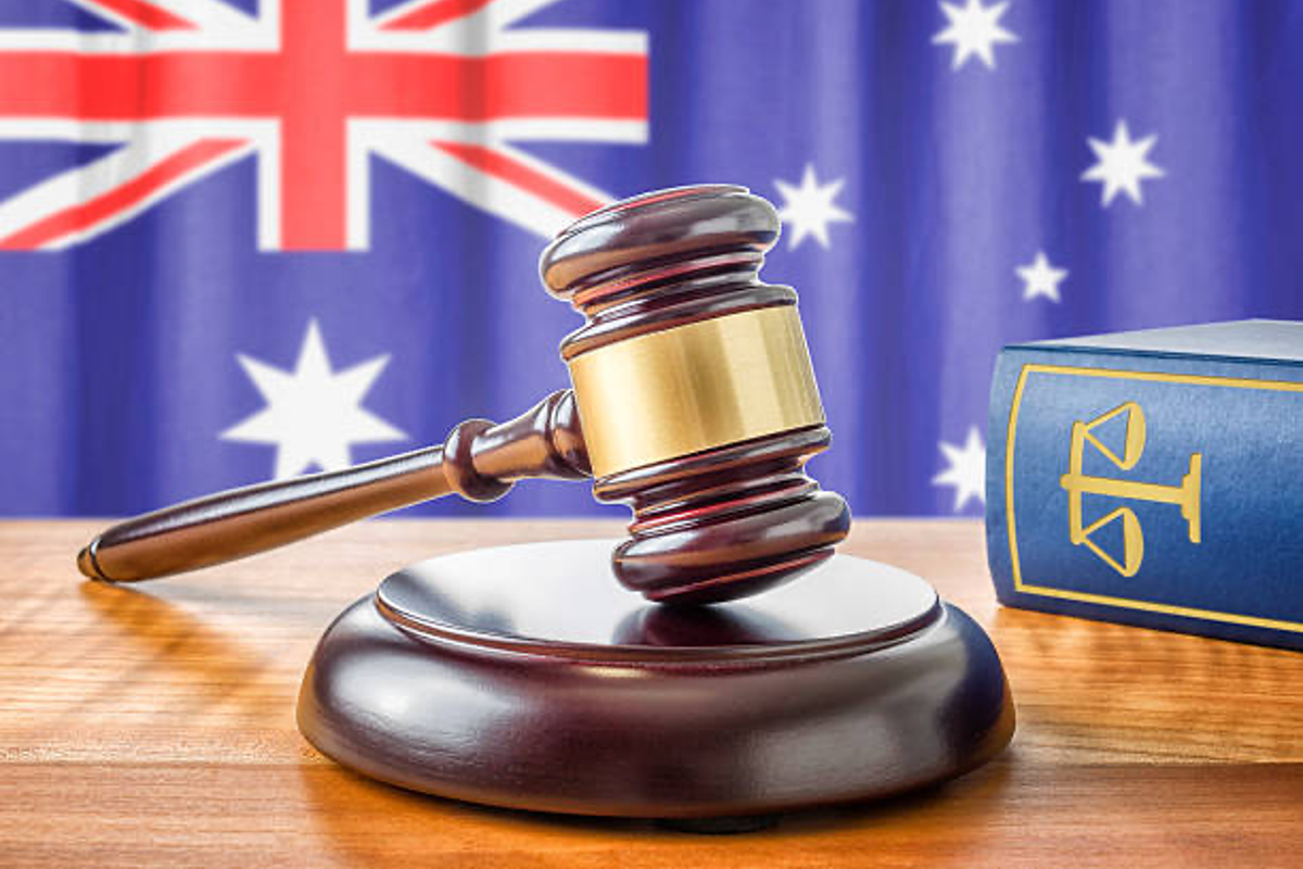 Gavel and book with Australian flag in the background.