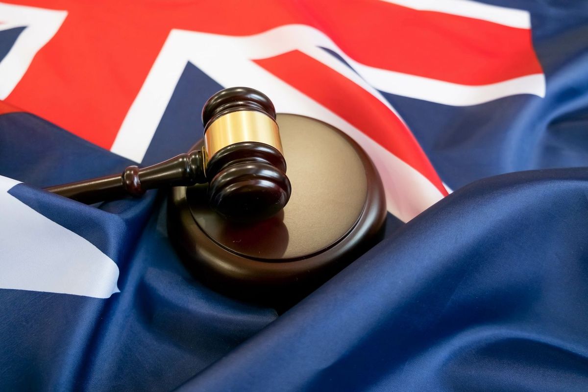 Gavel on a judge's block atop an Australian flag background.