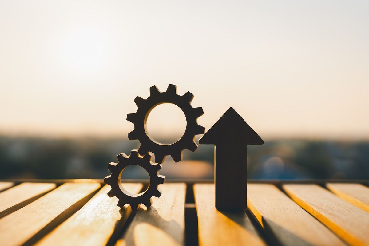 Gears beside up arrow.