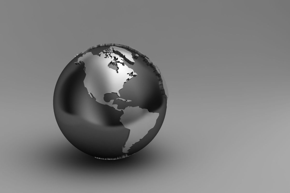 Globe made of silver metal showing North America and South America.