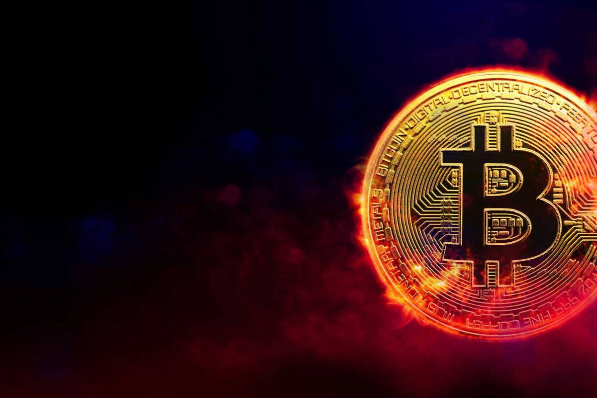 Glowing Bitcoin symbol over a dark, fiery background.