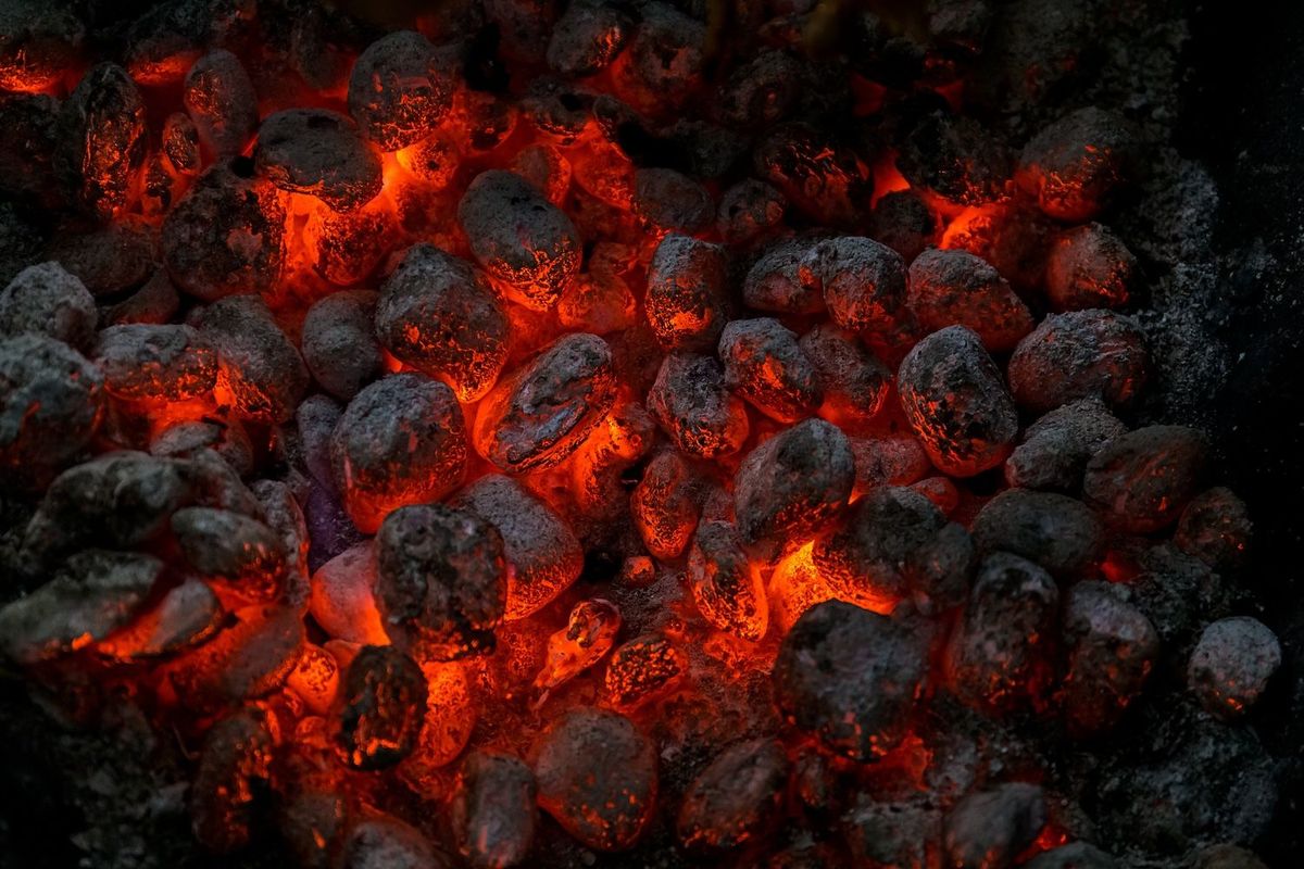 Glowing charcoal briquettes with bright orange embers.