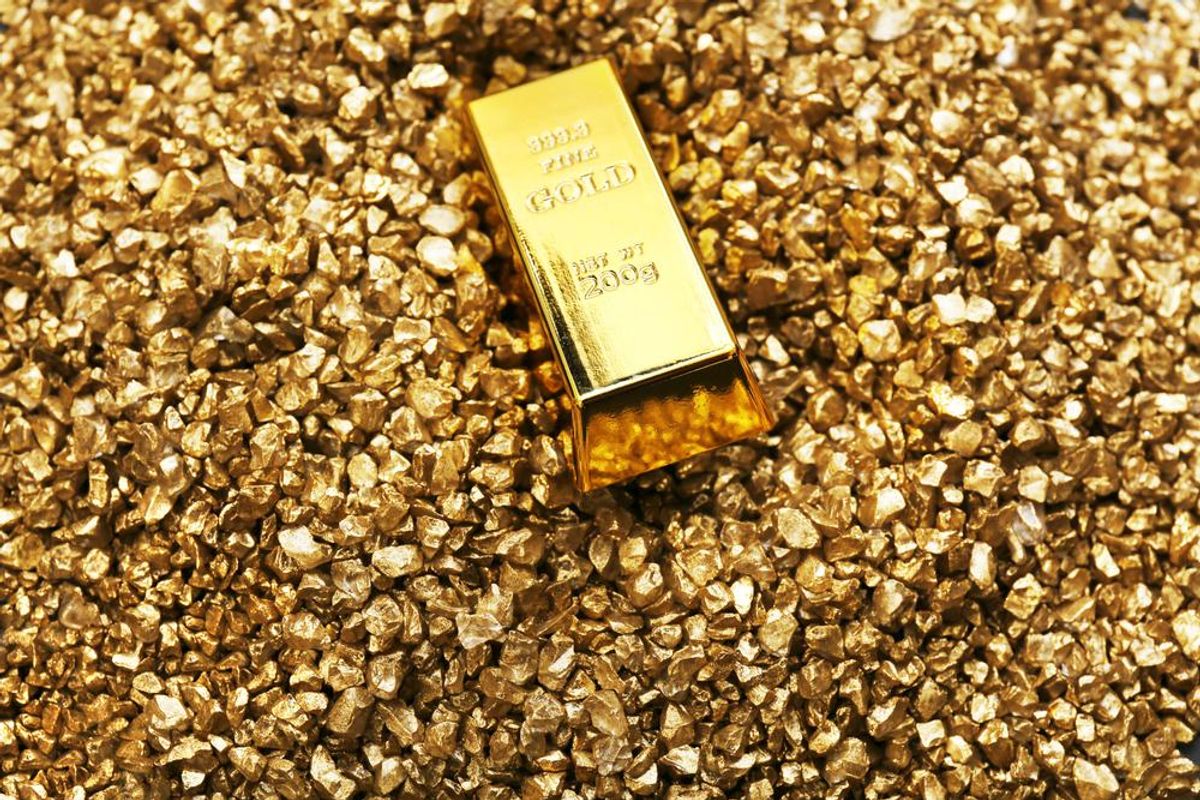 Gold bar on top of many gold nuggets.