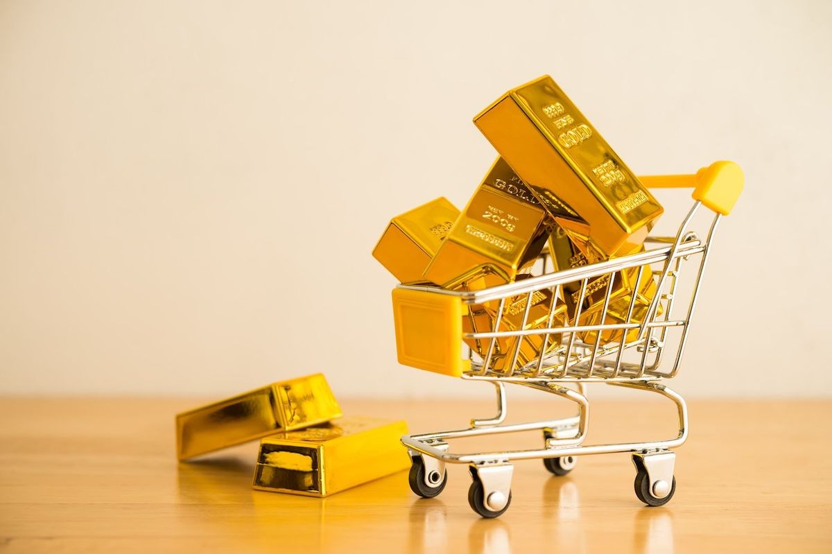 Gold bars in mini shopping cart.