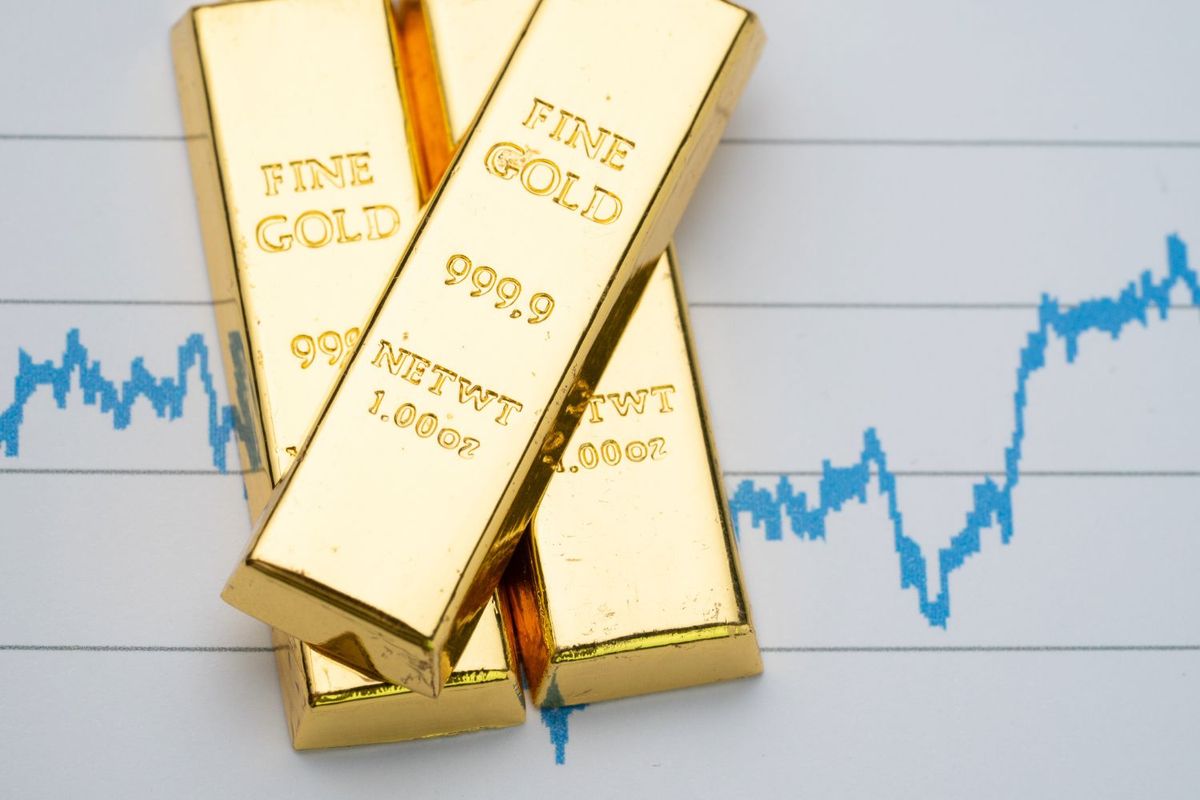 Gold bars on a financial chart background.