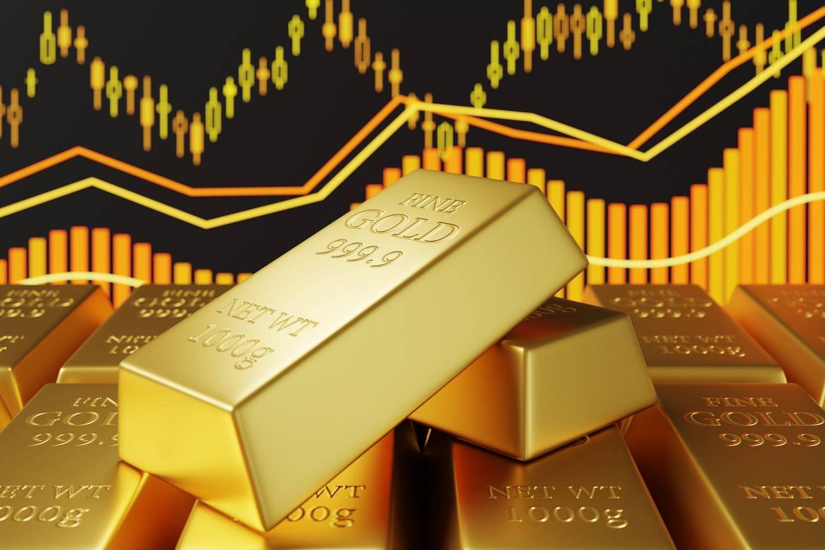 Gold bars over a background of yellow and orange financial charts.