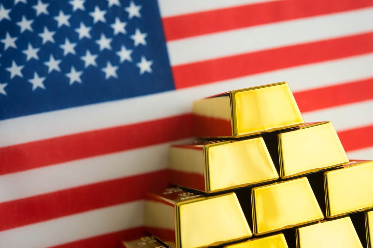 Gold bars stacked in front of American flag.