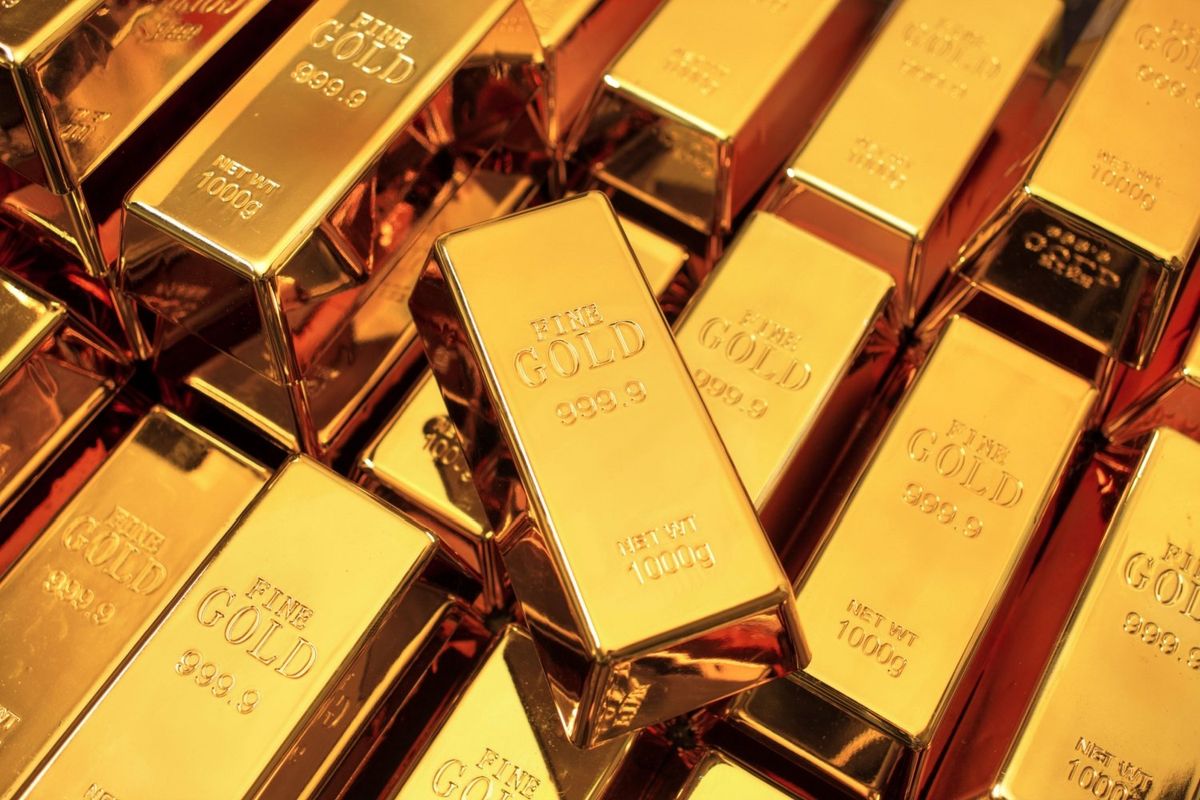 Gold bars stacked on top of each other with one in focus in the middle.
