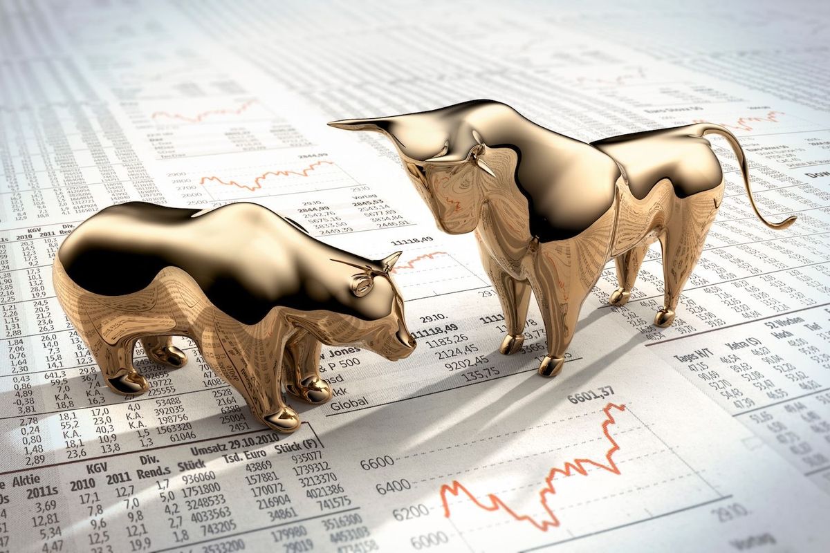 Gold bear and bull on a newspaper.