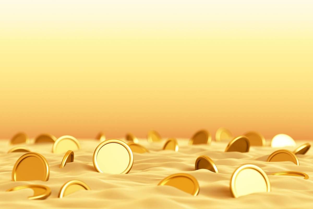 Gold coins partially buried in sand against a gradient yellow background.