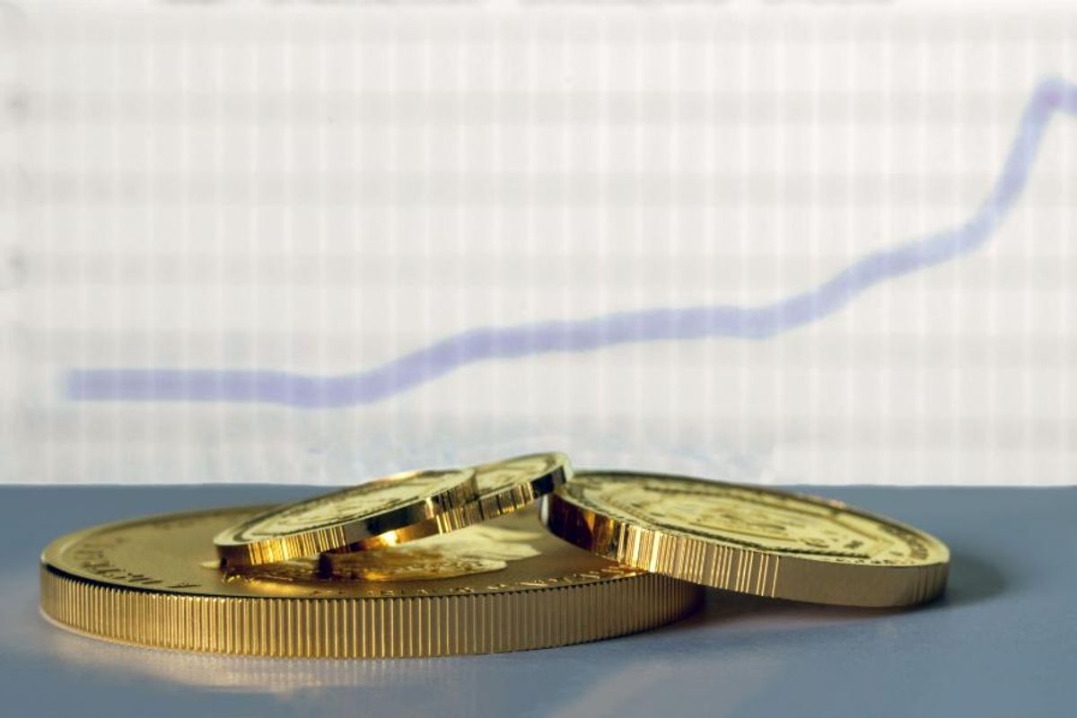gold coins with stock chart