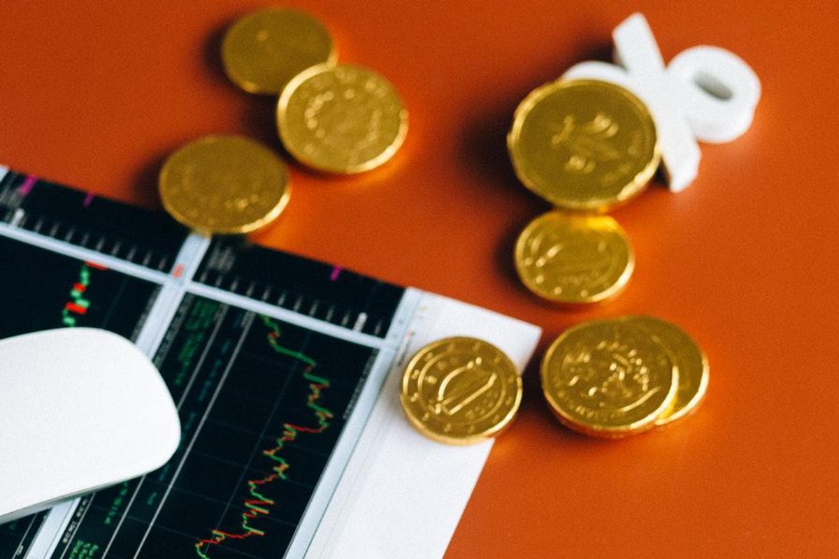 gold coins with trading chart