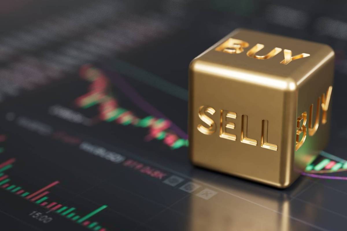 Gold cube labeled "buy" and "sell," stock chart in background.