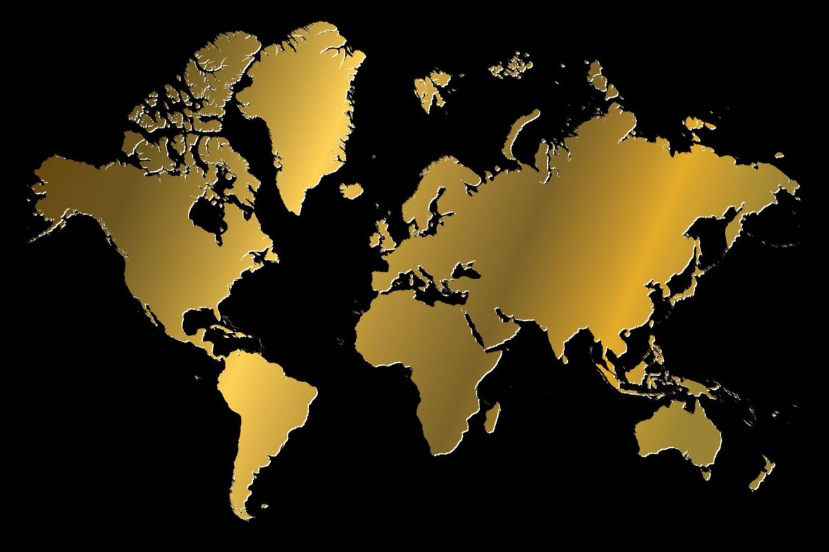 Gold map of the world over black background.