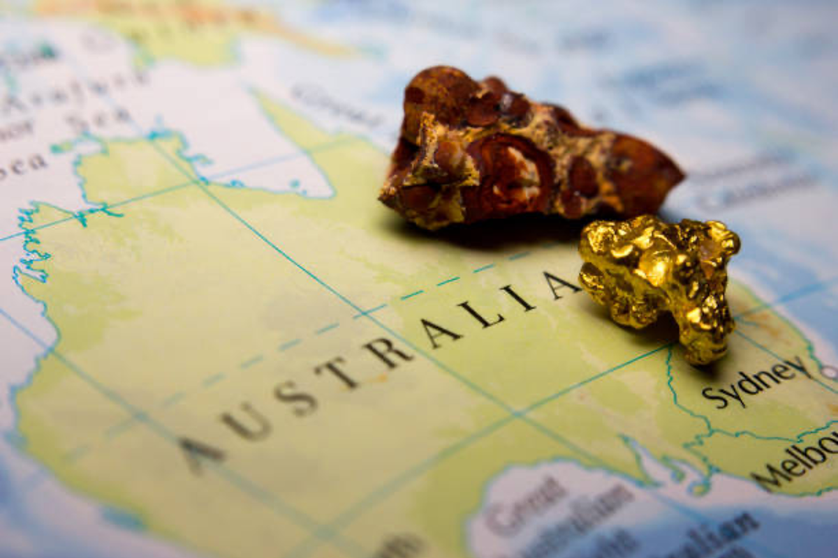 Gold nugget and ore on top of Australia map.
